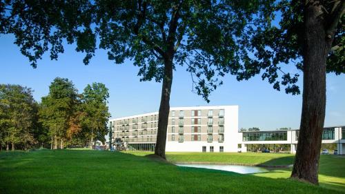 an office building with trees in front of it at Aparthotel Termy Uniejów in Uniejow