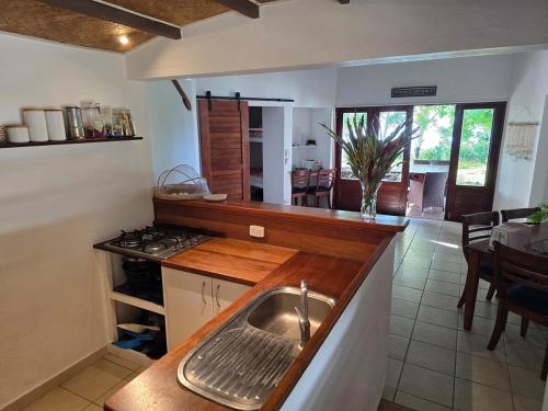 a kitchen with a sink and a kitchen with a table at Angels Beachhouse - Beachfront, fast internet, Queen beds, new owners in Port Vila