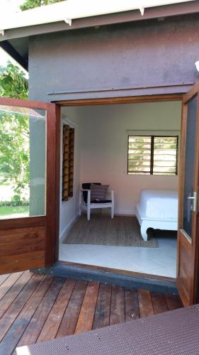 an open door to a patio with a bench on a deck at Angels Beachhouse - Beachfront, fast internet, Queen beds, new owners in Port Vila
