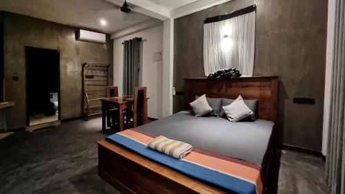 a bedroom with a bed with a wooden head board at Black Pearl Apartments - with free snorkeling Mirissa in Mirissa