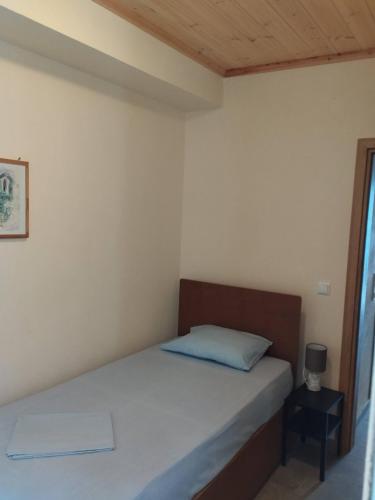 a bedroom with a bed with a blue pillow at Jenny's House II in Skiathos Town