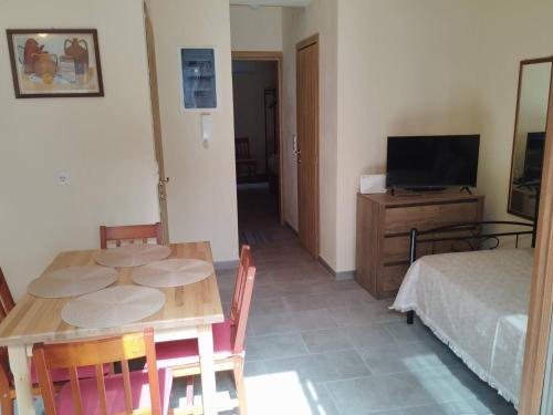 a room with a table and a bed and a television at Jenny's House II in Skiathos Town