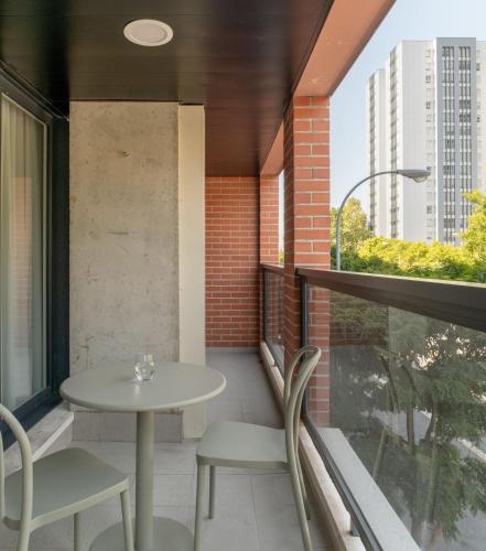 a balcony with a table and chairs and a window at Líbere Pamplona Universidad in Pamplona