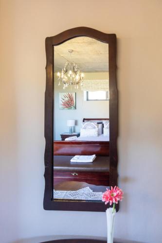 a mirror on a wall with a bed in a room at Mountain View Villa in Springbok