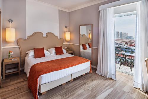 una habitación de hotel con una cama y un balcón en Starhotels Terminus, en Nápoles