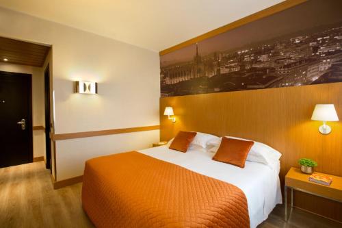 a hotel room with a large bed and a painting on the wall at Starhotels Tourist in Milan