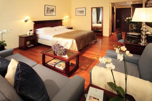 a hotel room with a bed and a living room at Starhotels Excelsior in Bologna