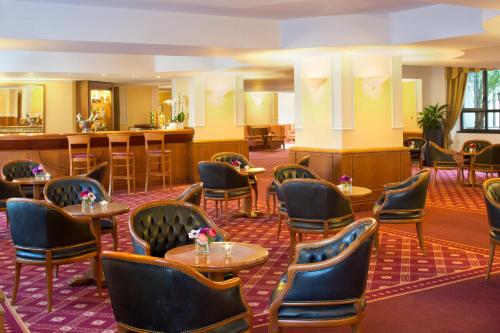 a hotel lobby with tables and chairs and a bar at Starhotels Business Palace in Milan