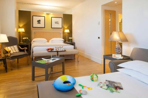 a hotel room with two beds and a living room at Starhotels Tuscany in Florence
