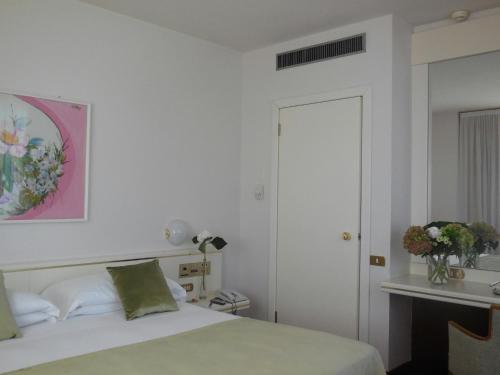 a bedroom with a bed and a vase of flowers at Starhotels Cristallo Palace in Bergamo