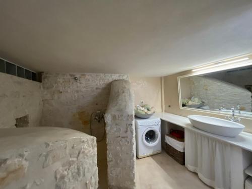 a bathroom with a sink and a washing machine at Ampelas View in Ambelas