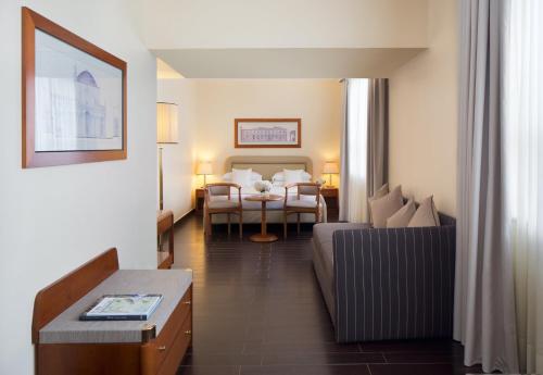 a hotel room with a bed and a living room at Starhotels Business Palace in Milan