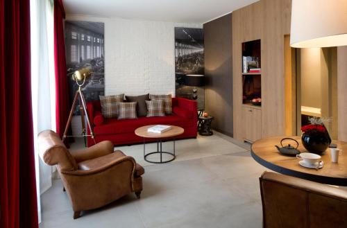 a living room with a red couch and a table at Starhotels Business Palace in Milan
