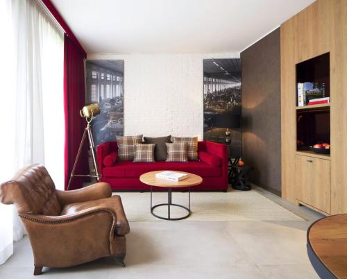 a living room with a red couch and a table at Starhotels Business Palace in Milan