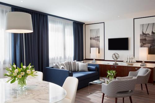 a living room with a blue couch and a table at Starhotels President in Genova