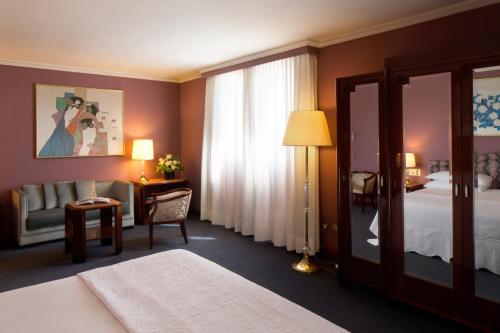 a hotel room with a bed and a mirror at Starhotels Du Parc in Parma