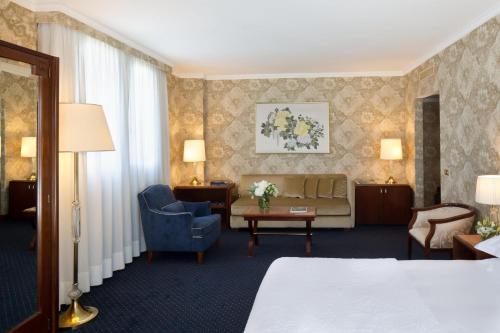 a hotel room with a bed and a couch at Starhotels Du Parc in Parma