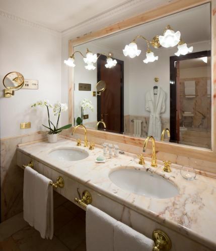 a bathroom with two sinks and a large mirror at Starhotels Du Parc in Parma