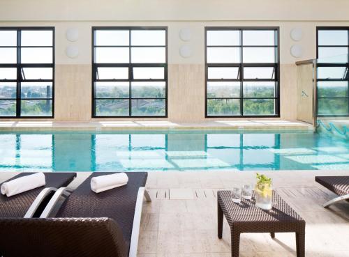 a large swimming pool with chairs and a table at Starhotels Grand Milan in Saronno