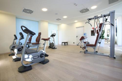 a gym with treadmills and elliptical machines at Starhotels Grand Milan in Saronno