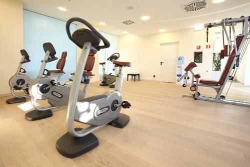 a gym with treadmills and elliptical machines at Starhotels Grand Milan in Saronno