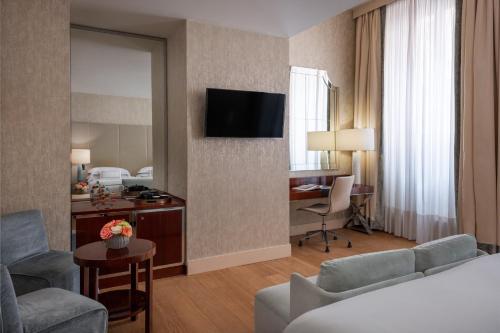a hotel room with a bed and a desk at Rosa Grand Milano - Starhotels Collezione in Milan