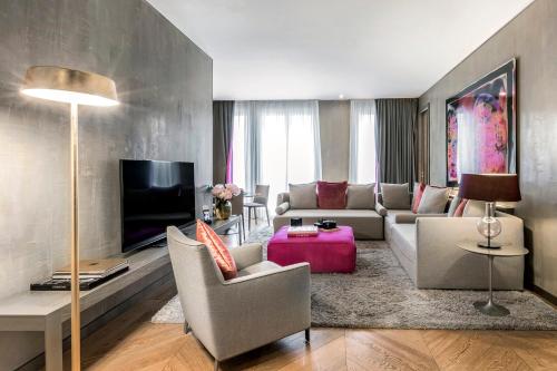 a living room with a couch and a tv at Rosa Grand Milano - Starhotels Collezione in Milan