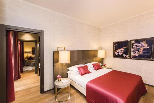 a bedroom with a large bed with a red blanket at Rosa Grand Milano - Starhotels Collezione in Milan