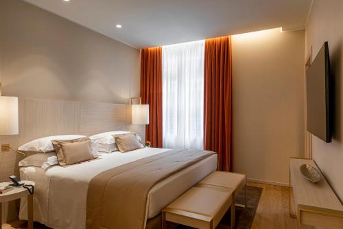 a hotel room with a bed and a window at Rosa Grand Milano - Starhotels Collezione in Milan