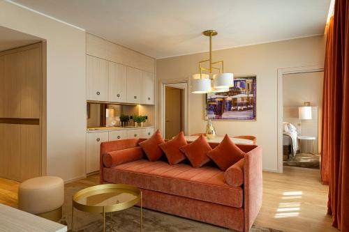 a living room with a couch and a kitchen at Rosa Grand Milano - Starhotels Collezione in Milan