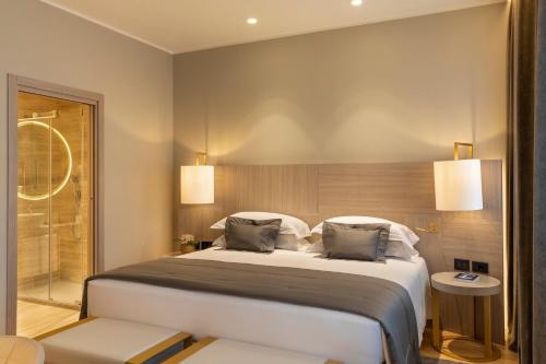 a bedroom with a large bed with two pillows at Rosa Grand Milano - Starhotels Collezione in Milan