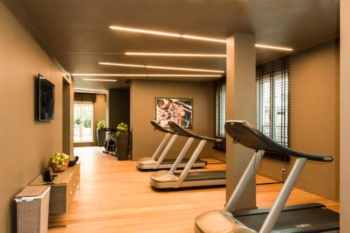a gym with three exercise bikes in a room at Rosa Grand Milano - Starhotels Collezione in Milan