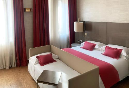 a hotel room with two beds with red pillows at Rosa Grand Milano - Starhotels Collezione in Milan
