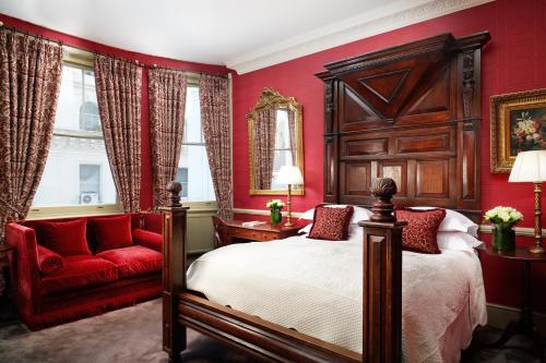 a red bedroom with a bed and a red chair at The Gore London - Starhotels Collezione in London