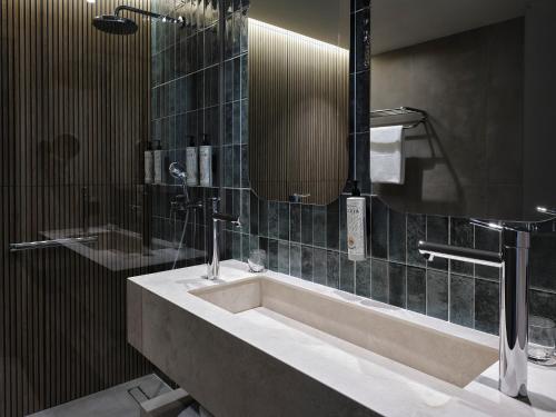 a bathroom with a sink and a mirror at Amus Hotel & Spa in Ixia