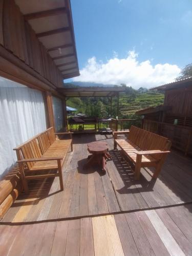 two wooden benches sitting on a deck with a view at Varvara hill in Cigugur