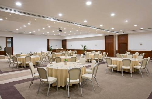a banquet hall with tables and chairs and a projection screen at Starhotels Majestic in Turin
