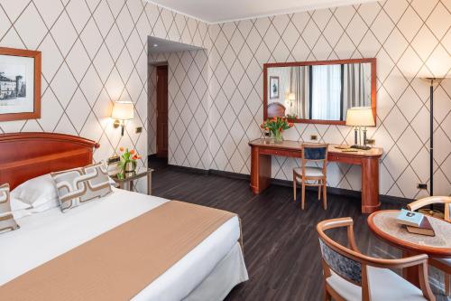 a hotel room with a bed and a desk at Starhotels Majestic in Turin