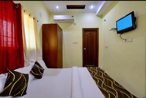 a bedroom with a bed with a television on the wall at Hotel Al Zaiqa in Durg