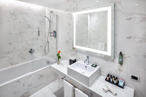 a white bathroom with a sink and a shower at Starhotels Majestic in Turin
