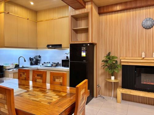 a kitchen with a wooden table and a black refrigerator at Chapis Transient Home in Baguio