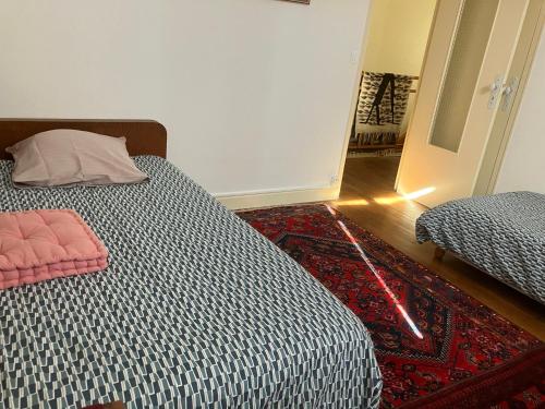 1 dormitorio con 2 camas y alfombra roja en Le Tilleul, en Prémilhat
