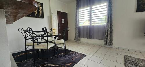 a dining room with a table and a chair at Residence St Antoine in Cayenne
