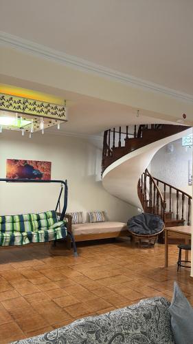 a living room with a staircase and a couch at HeidiHouse in Patra