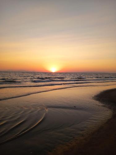 a sunset on a beach with the ocean at La Casa del Sole in Follonica