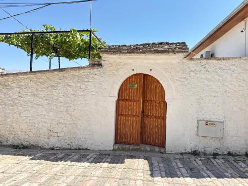 a building with a wooden door on the side of it at Mezini Guest House in Gjirokastër