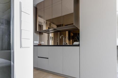 a kitchen with white cabinets and a sink at Luxury Honey Moon Apartments with Free Underground Parking in Kaunas