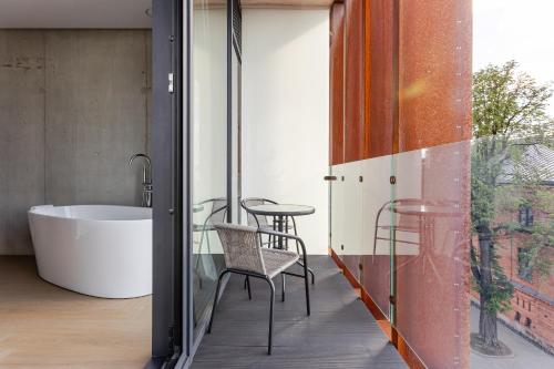 a bathroom with a tub and a table and chairs at Luxury Honey Moon Apartments with Free Underground Parking in Kaunas