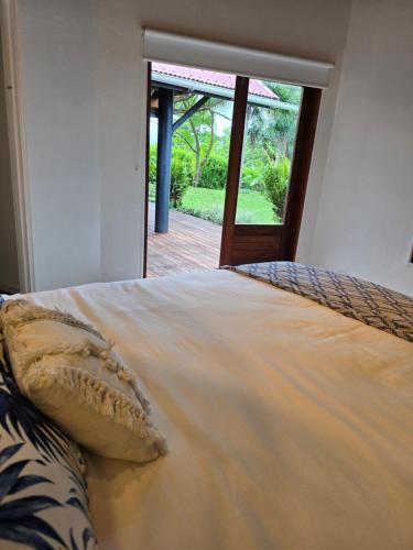 a large bed in a room with a large window at Angels Beachhouse - Beachfront, fast internet, Queen beds, new owners in Port Vila