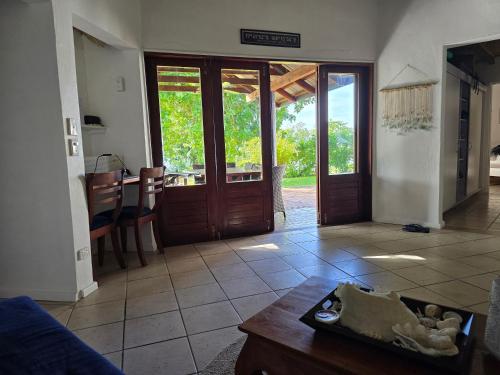 a living room with a couch and a table and doors at Angels Beachhouse - Beachfront, fast internet, Queen beds, new owners in Port Vila